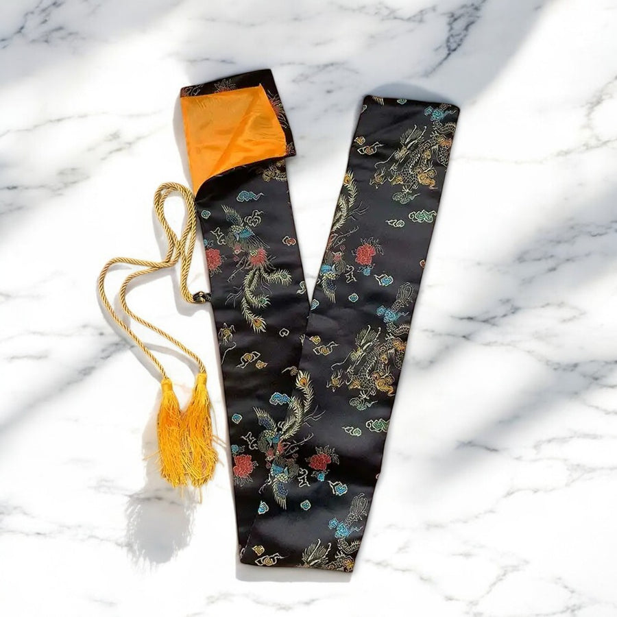 Black patterned katana bag with orange lining, gold drawstring and tassel