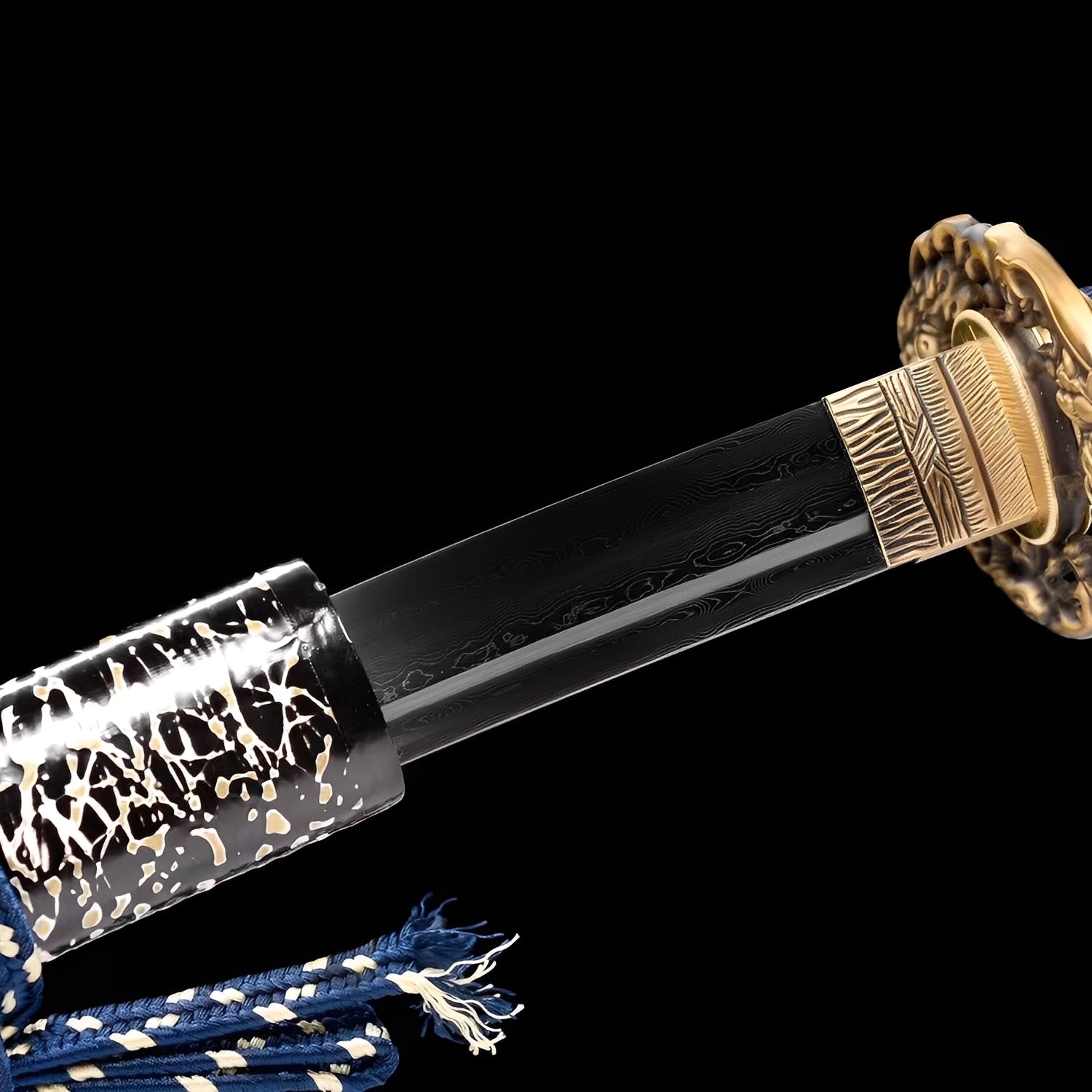 Shimokaminari Katana close-up showing dark Damascus blade with subtle engravings, gold sculptural dragon tsuba, brass habaki with rain-stripe texture, and navy cotton ito with white menuki over synthetic rayskin