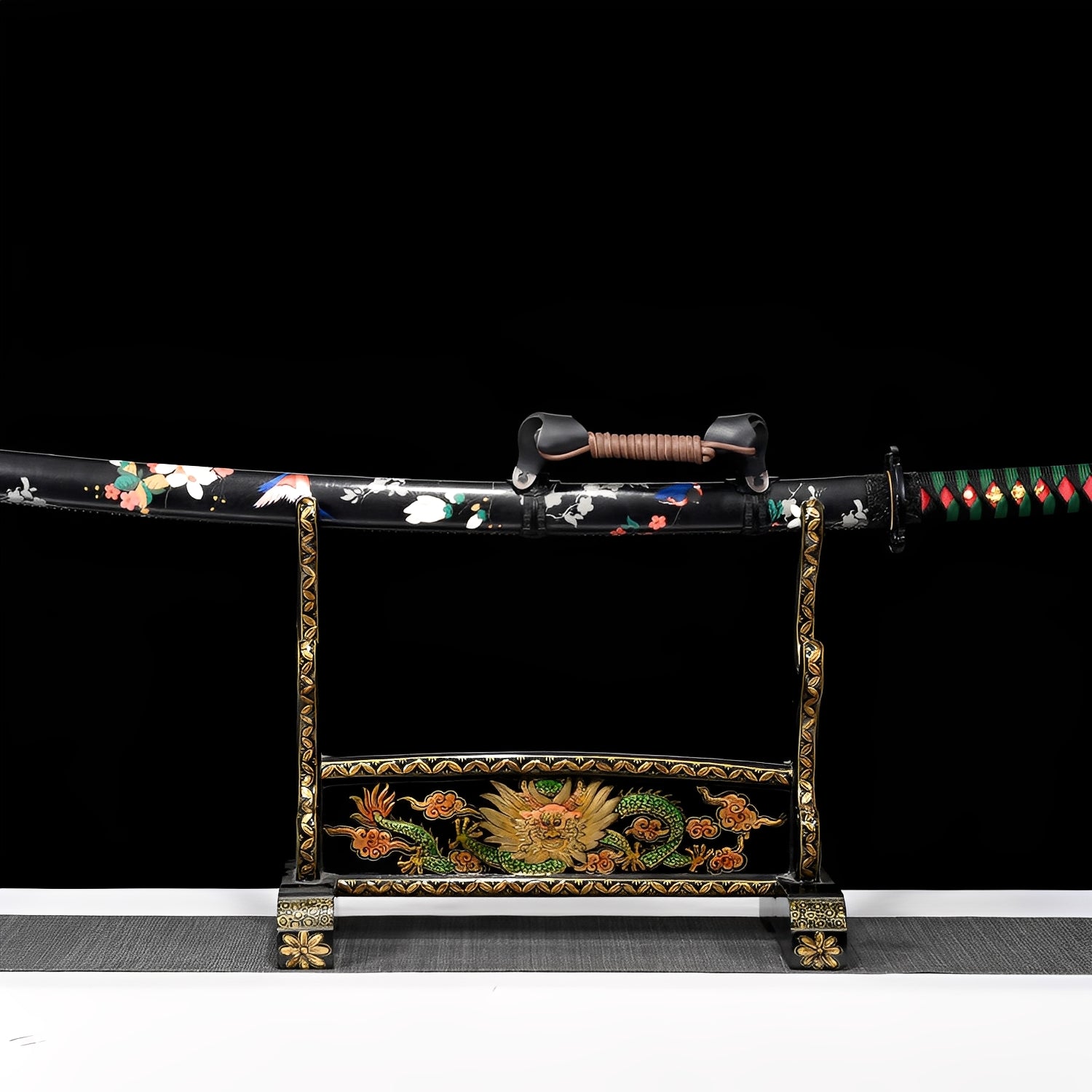 Shirakawa katana saya detail showing pink-white cherry blossom flowers and green leaves painted across glossy black lacquer surface