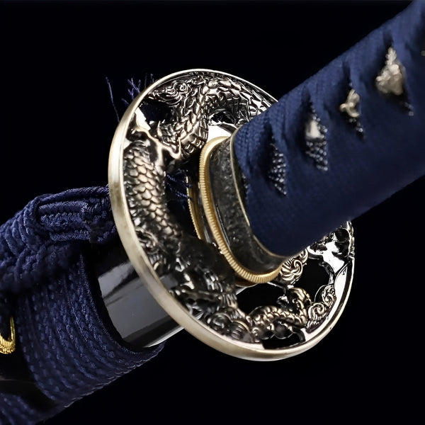 Blue dragon katana close-up showing golden openwork tsuba and navy cotton handle wrapping