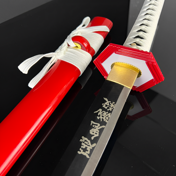 Giyu katana blade detail showing engraved kanji characters on black-finished section near brass habaki