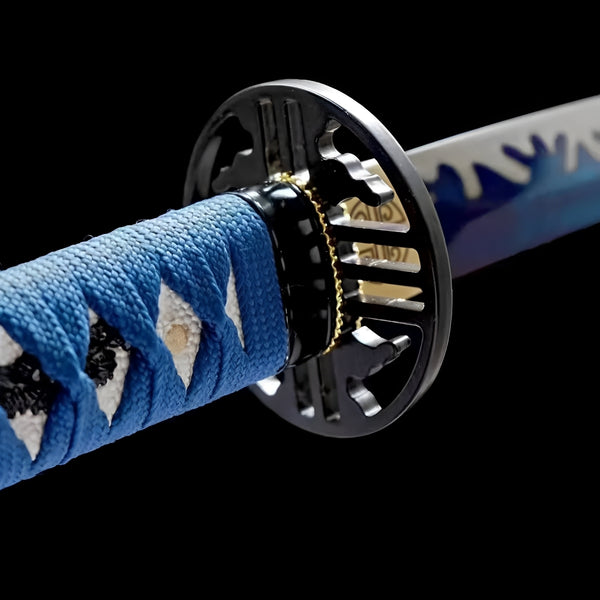 Hekinan Katana close-up showing blue blade with white wave splash pattern, iron geometric openwork tsuba, brass habaki with spiral crest, and sky-blue ito over white rayskin