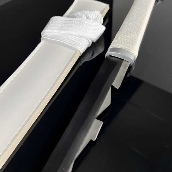 Inosuke Katana blade close-up showing serrated edge with rectangular teeth along the cutting line on polished 1060 carbon steel