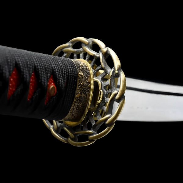Shinku Wakizashi close-up showing Damascus blade with visible grain, copper sculpted tsuba with dragon relief, copper openwork habaki, and red-black cotton ito
