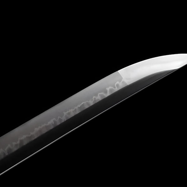 Shirokuro katana blade detail showing notare hamon on hand-polished T10 steel emerging from buffalo horn koiguchi