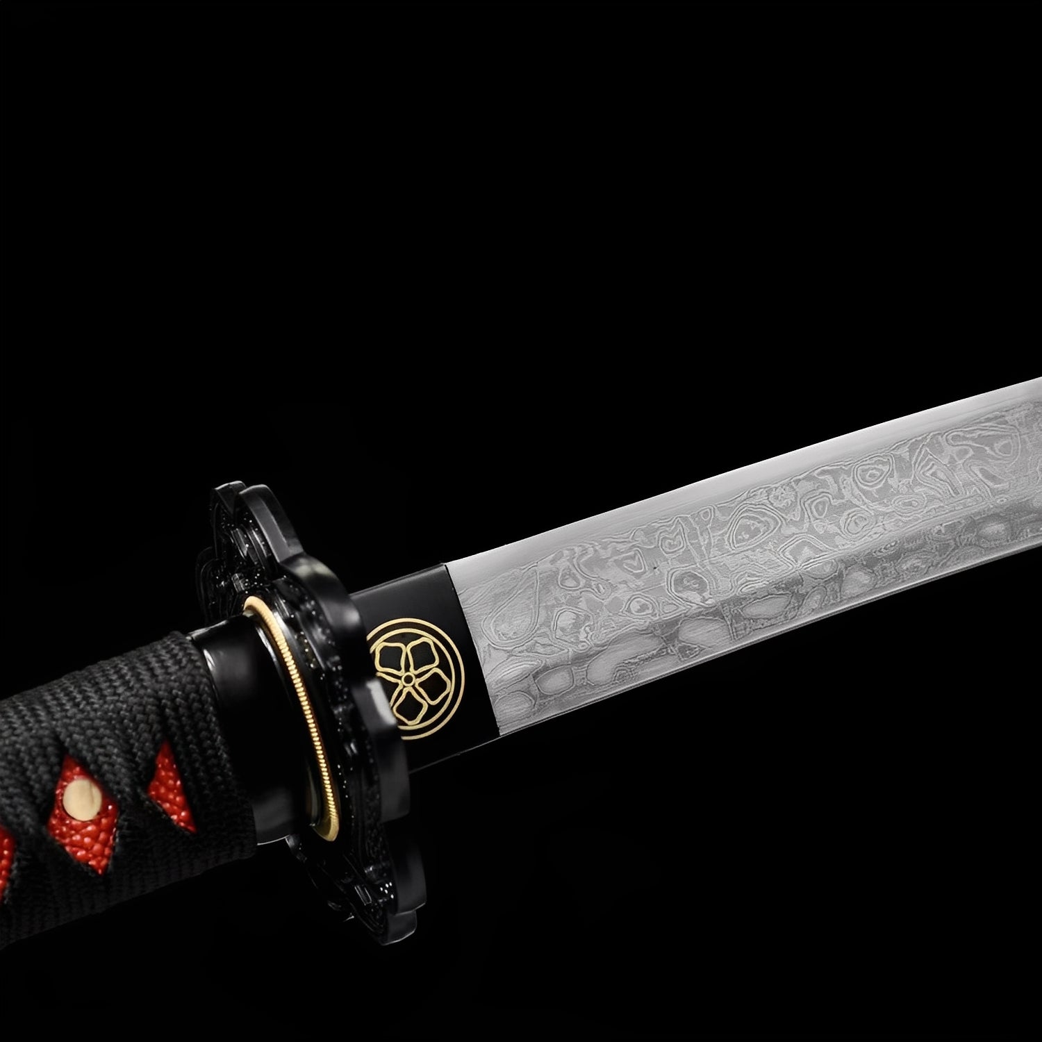 Akanokiba Katana close-up showing Damascus blade with dense folded cloud-wave pattern, black iron-alloy dragon tsuba with gold rim, brass habaki with gold mon crest, and black cotton ito over red synthetic rayskin