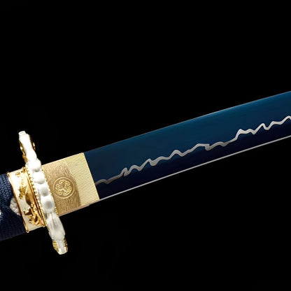 Aokami Katana close-up showing blue 1060 blade with white wave-lightning engravings, ivory-gold dragon tsuba with sculptural 3D form, brass habaki with mon crest, and navy cotton ito over synthetic rayskin