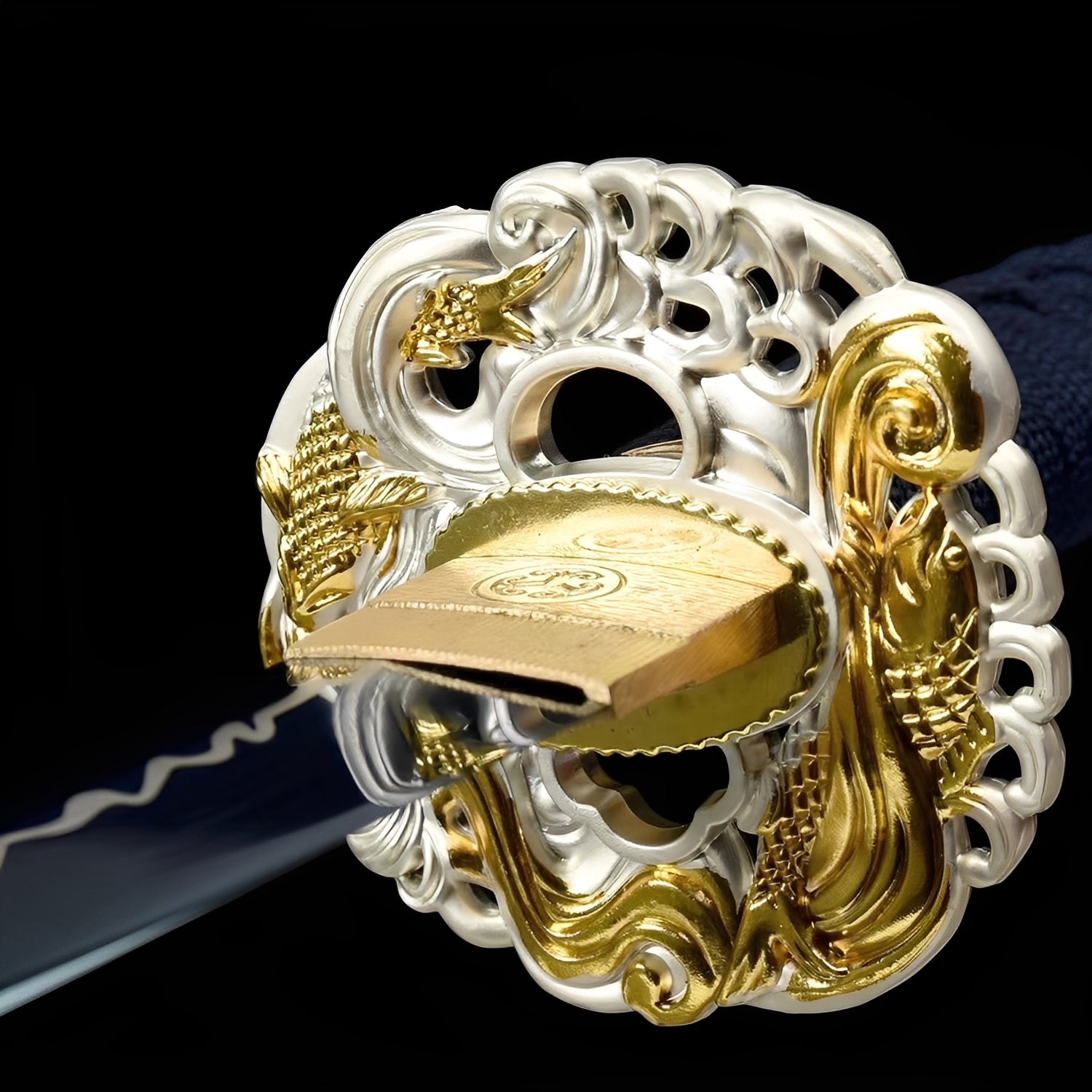 Aokami katana tsuba detail showing ivory-finished iron-alloy guard with gold 3D dragon wrapping around the disc and brass habaki with circular mon