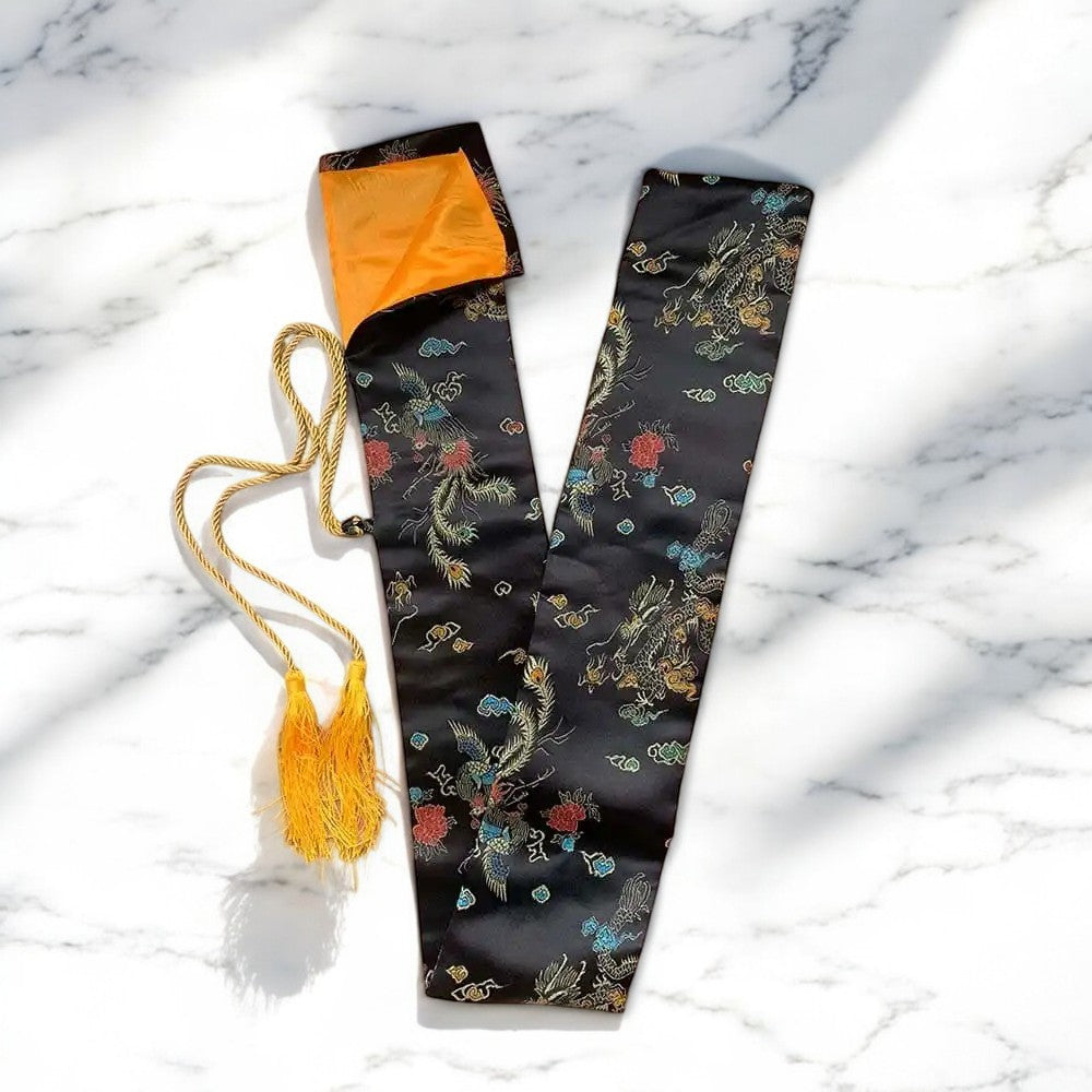 Black patterned katana bag with orange lining, gold drawstring and tassel