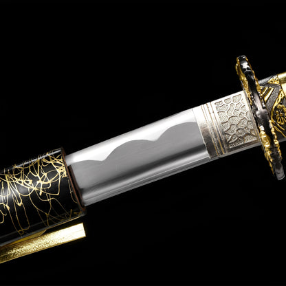 Kinkuro Katana close-up showing polished 1060 blade with hamon, chrome-gold dragon openwork tsuba, silver engraved habaki, and gold PU leather ito with chrysanthemum menuki over synthetic rayskin