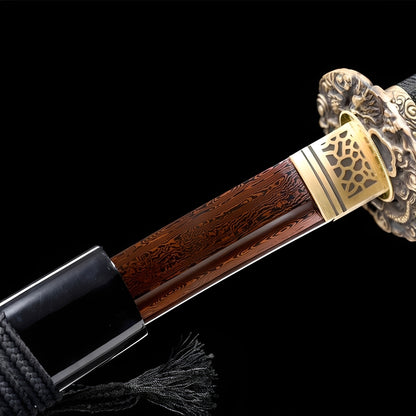 Kiso Hida Katana close-up showing red Damascus blade with copper-toned folded grain, copper dragon tsuba with honeycomb habaki, and black cotton ito over genuine rayskin