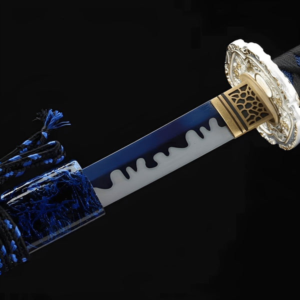 Nightwater Katana close-up showing blue blade section with white dimensional drip pattern, chrome dragon-floral tsuba with openwork, and brass honeycomb habaki