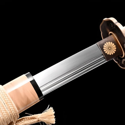 Royal Shinto Katana close-up showing polished 1060 blade with double bo-hi grooves, copper octagonal tsuba with golden sixteen-petal chrysanthemum, and cream cotton ito