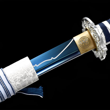Winter Spirit Katana close-up showing blue blade with white mountain line engraving, chrome dragon tsuba, brass habaki with mon crest, and navy-white striped cotton ito
