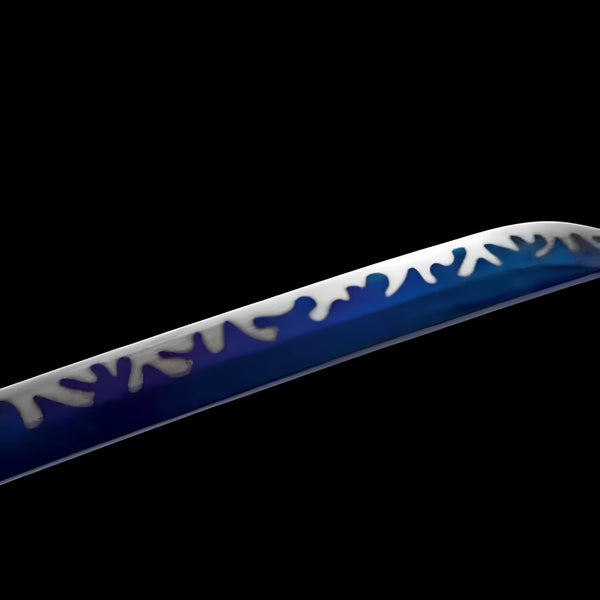 Hekinan katana blade detail showing white Great Wave-style pattern on blue-gradient steel near brass habaki