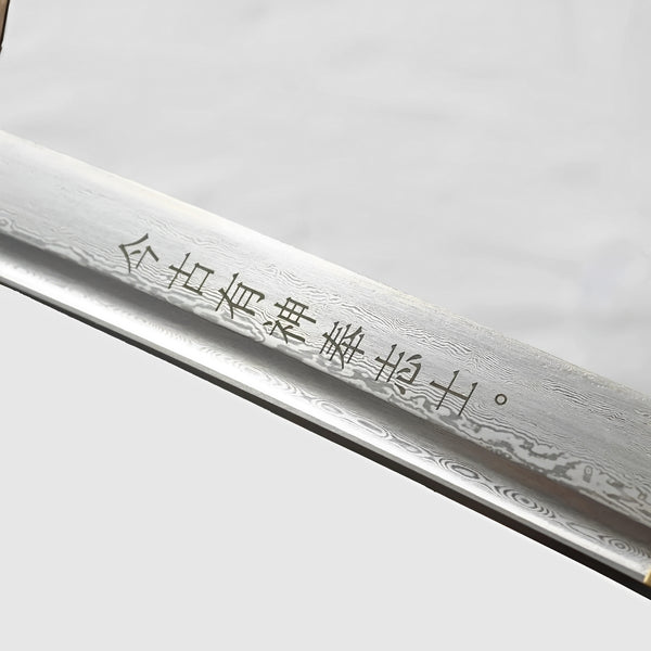 Kill Bill katana blade detail showing Damascus grain pattern, hamon temper line, and Japanese character inscriptions