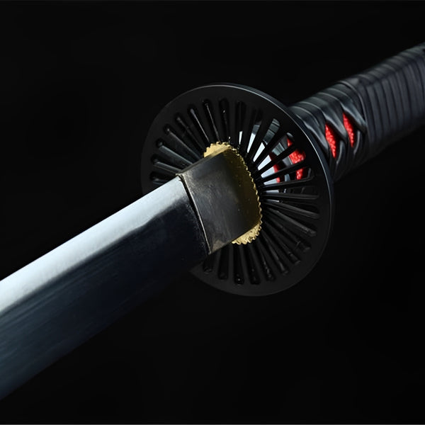 Nichirin Katana close-up showing black sun-ray iron tsuba with gold center and polished 1060 carbon steel blade