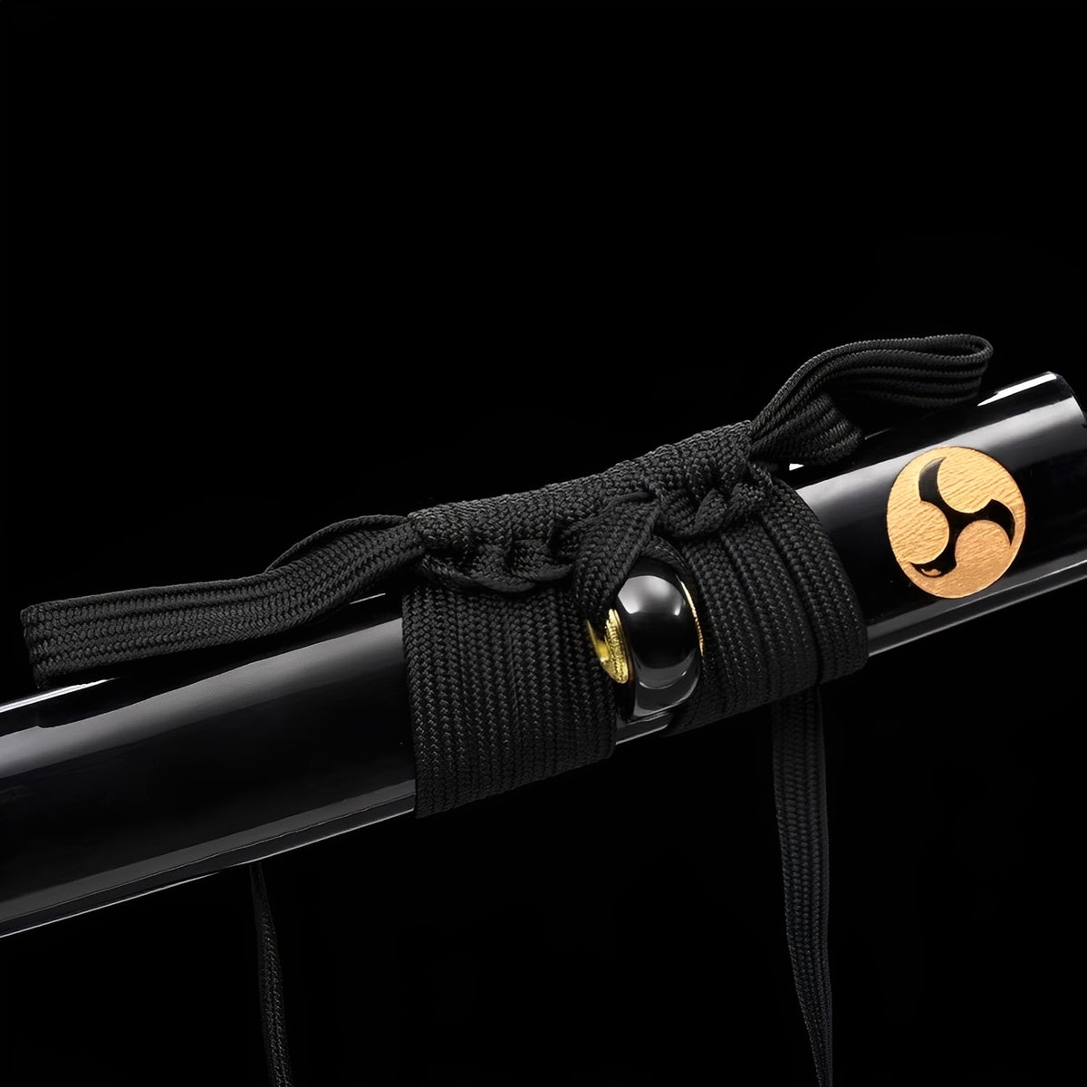 Gold-colored mitsudomoe emblems on the glossy black saya