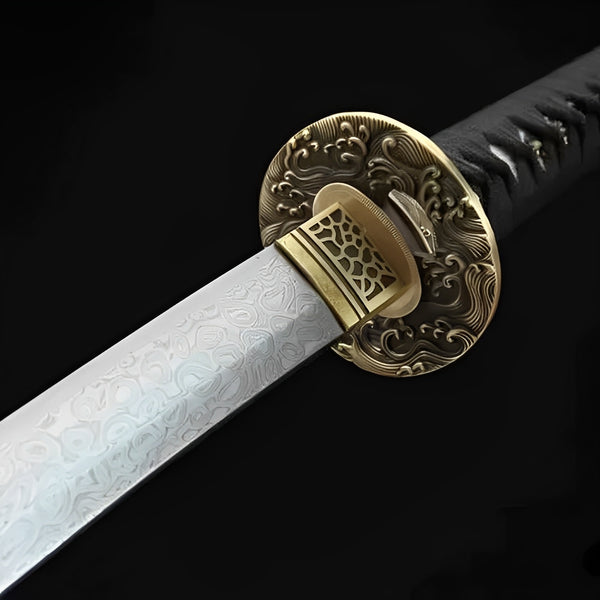 Yugure Katana close-up showing Damascus blade with pronounced rose-pattern grain, copper wave-relief tsuba, carved brass openwork habaki, and black ito over genuine white rayskin